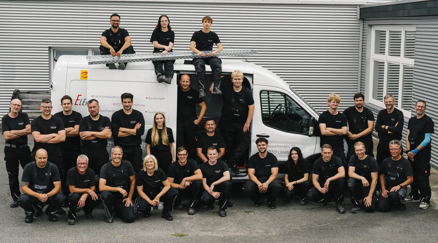 Das Team der ElektroTechnik Lüneburg vor und auf einem Firmenfahrzeug.