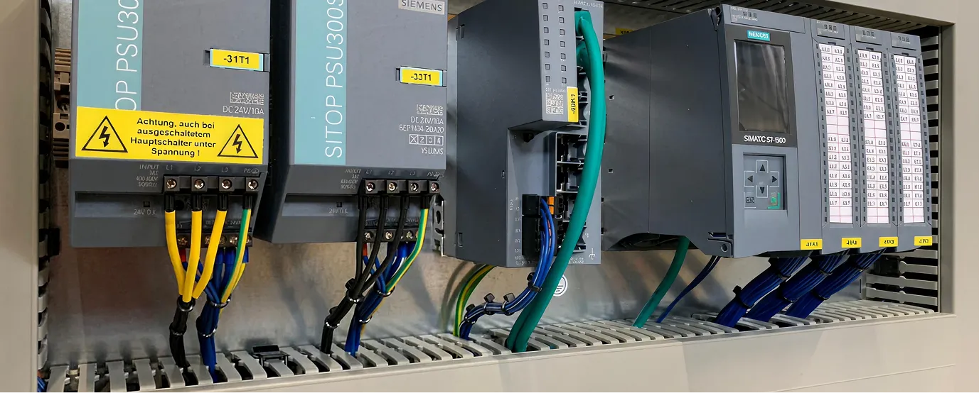 Industrielles Steuerungspanel mit Siemens SITOP PSU300S Netzteilen und SIMATIC S7-500 Automatisierungsmodul.